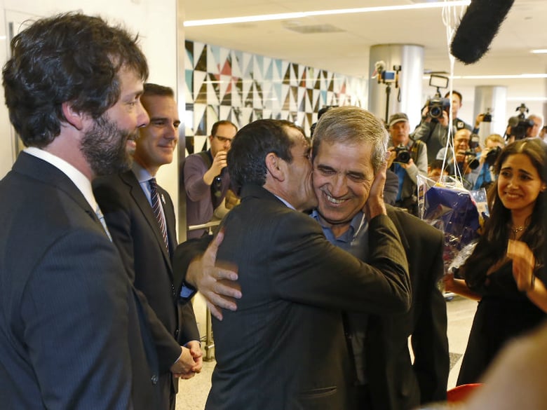 Ali Vayeghan, an Iranian citizen with a valid U.S. visa, third from left, kisses his brother Houssein Vayghan, with his Marjan Vayghan at Los Angeles International Airport Thursday, Feb. 2, 2017. 