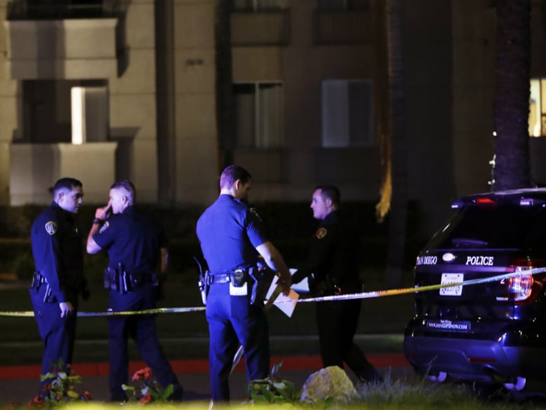 San Diego police officers stand in front of a cordoned off La Jolla apartment after a shooting Sunday, April 30, 2017, in San Diego. 