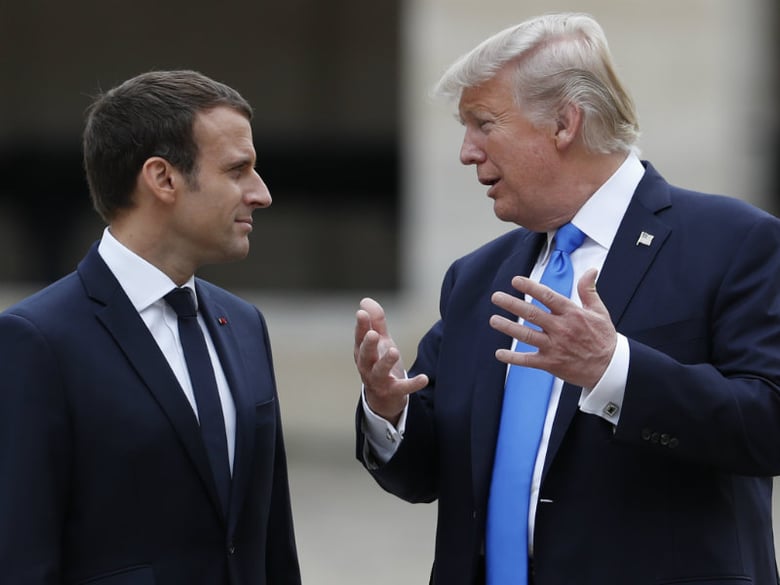 French President Emmanuel Macron listens to U.S. President Donald Trump, right, in the courtyard of les Invalides after a welcoming ceremony in Paris, Thursday, July 13, 2017. 