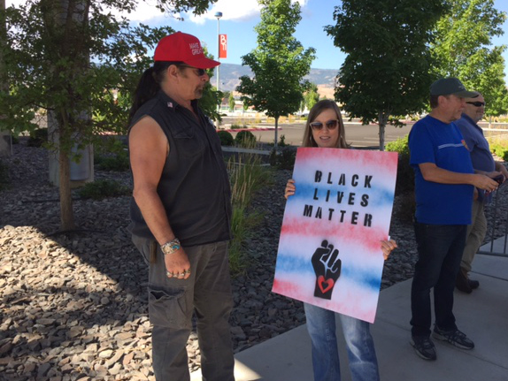 Trump supporter Kevin Coffey and protester Cathy Blane, both of Reno, chat outside the Reno Convention Center on Wednesday, August 23, 2017, while the president addressed the American Legion National Convention inside.