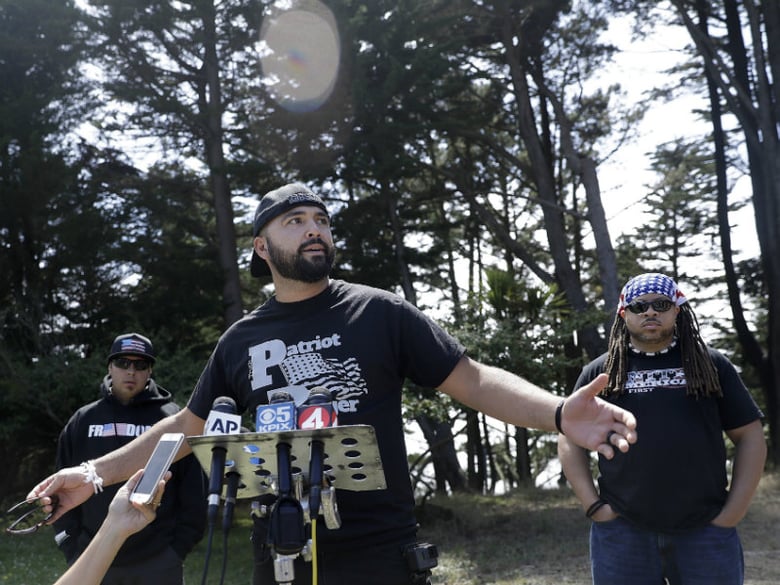 Joey Gibson of the group Patriot Prayer, center, speaks at a news conference in Pacifica, Calif, Saturday, Aug. 26, 2017. Officials took steps to prevent violence ahead of a planned news conference by the right-wing group. 