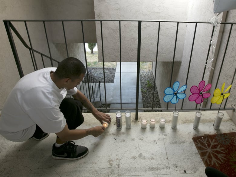 Simon Morales lights a candle at a makeshift memorial outside an apartment Thursday, Sept. 14, 2017, where three children were killed, in West Sacramento, Calif.