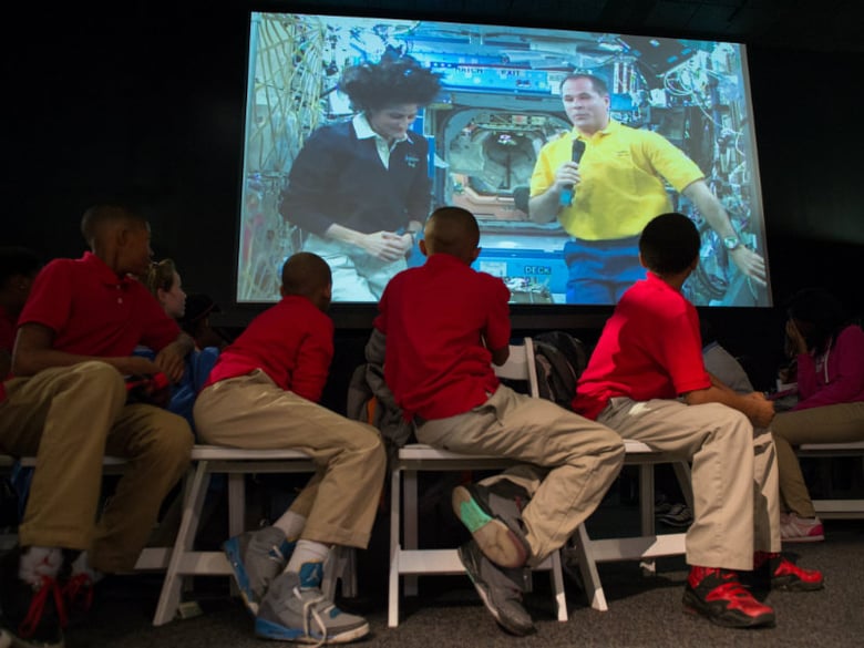 International Space Station Expedition 33 flight engineer Kevin Ford (on screen) answers questions from students during a downlink event held in honor of International Education Week at the Smithsonian National Air and Space Museum.
