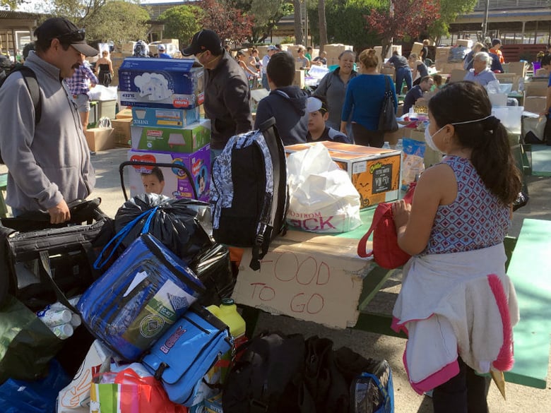 Wildfire evacuee Francisco Macias, a landscape worker from Santa Rosa, Calif., collects donated blankets, baby diapers and food supplies for his family at the Sonoma-Marin Fairgrounds in Petaluma, Calif., Sunday, Oct. 15, 2017.