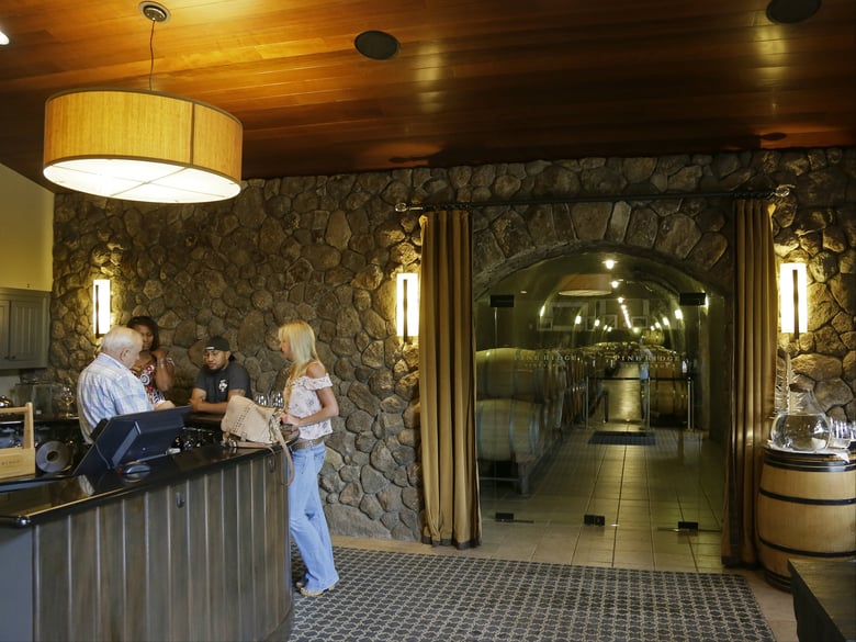In this Monday, Oct. 16, 2017 photo, people visit the Pine Ridge Vineyards tasting room after it reopened following the wildfires in Napa, Calif.