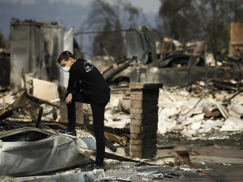 Benjamin Lasker, 16, pauses while looking at what remains of his home after a wildfire swept through Sunday, Oct. 15, 2017, in Santa Rosa, Calif. 