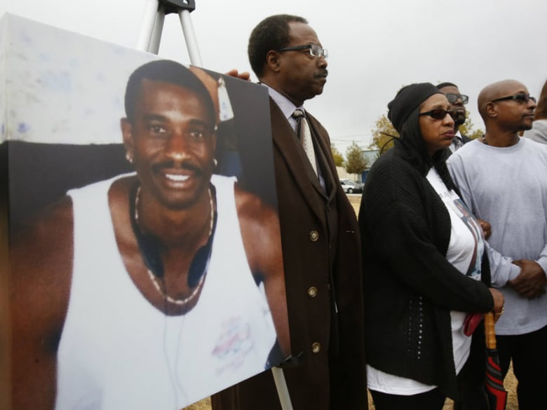 FILE - In this Oct. 3, 2016 file photo, a picture of Joseph Mann, who was killed by Sacramento Police last July, is displayed at a news conference held by his sister, Deborah, center, and brother, Robert Mann, right, in Sacramento, Calif. 