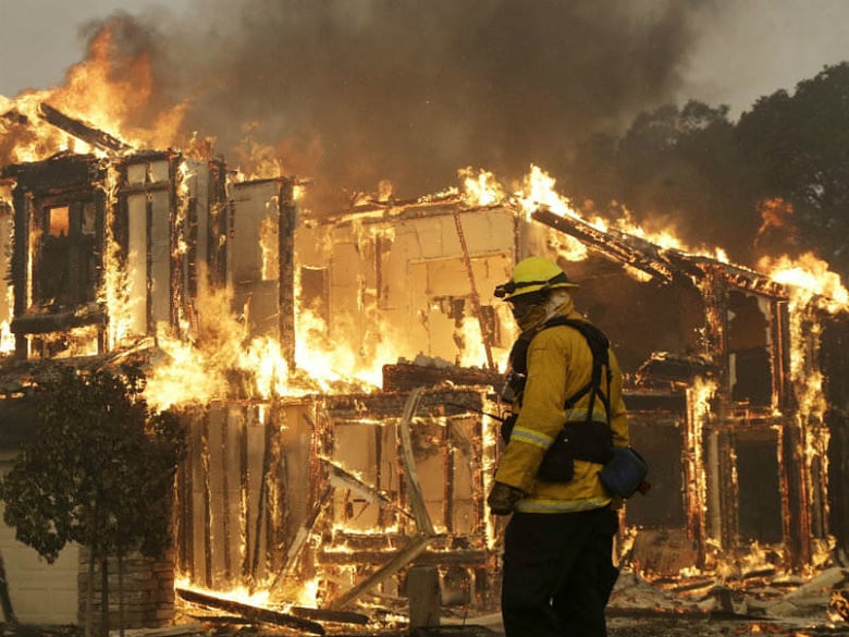 A firefighter monitors a house burning in Santa Rosa, Calif., Monday, Oct. 9, 2017. Wildfires whipped by powerful winds swept through Northern California causing residents to flee to safety through smoke and flames as homes burned. 