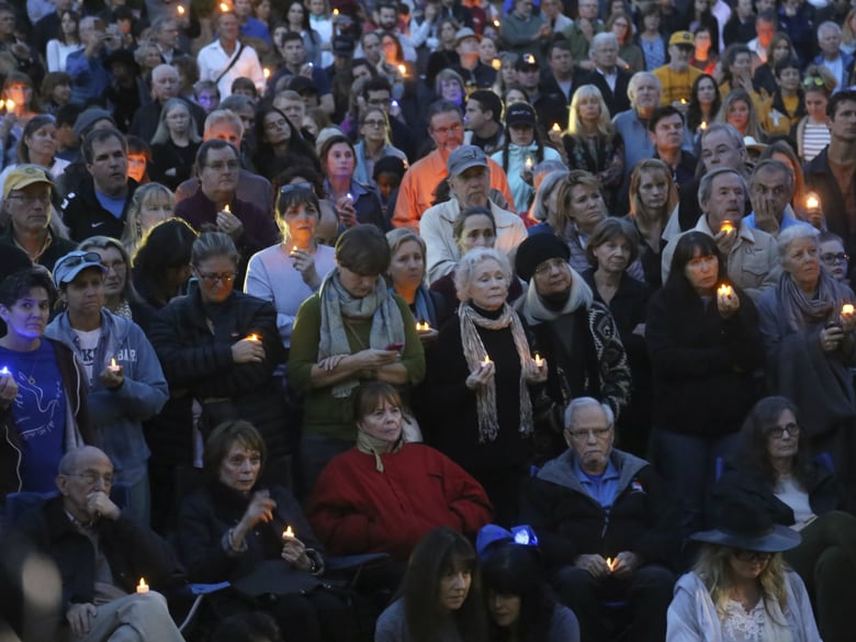 People attend a candlelight vigil in Santa Barbara, Calif., Sunday, Jan. 14, 2018, to pay tribute to the people who were killed when mudslides ravaged a Southern California. 