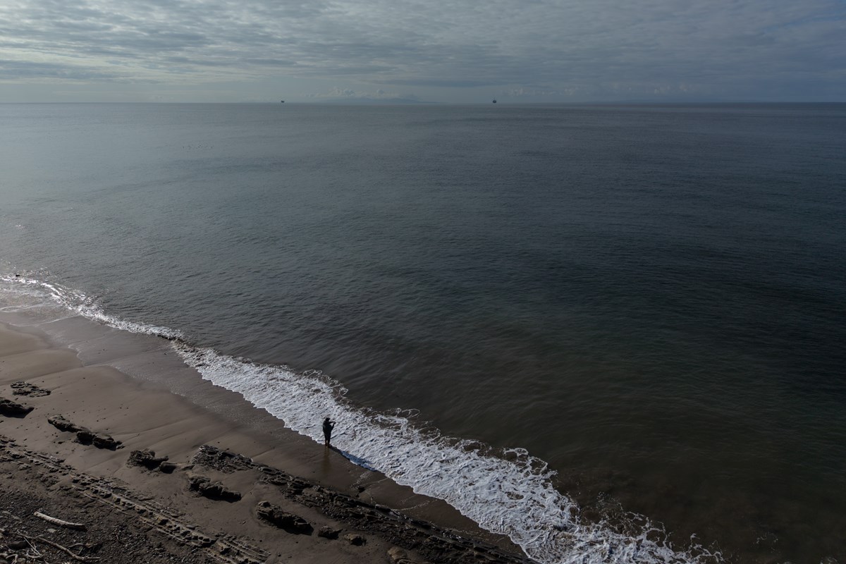 A person casts a fishing line into the ocean at Gaviota State Park in Santa Barbara County, Calif., Sunday, April 26, 2026, as an offshore drilling platform operated by Sable Offshore Corp. is seen in the distance.