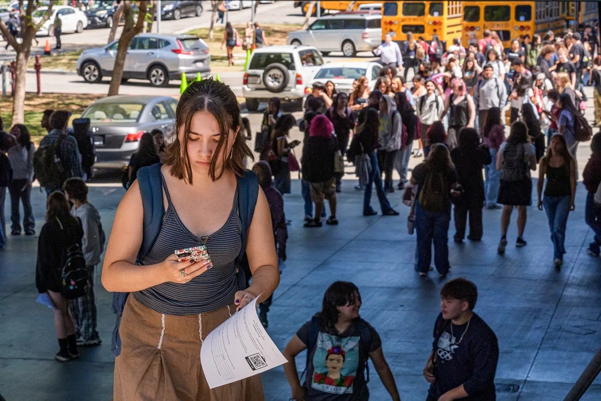 A student walks with a cell phone