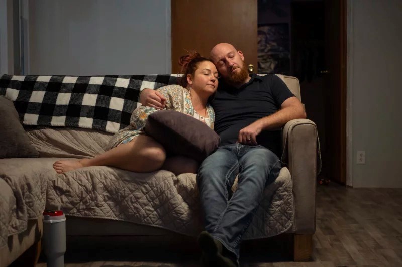 Erica and Wade Hanicker rest together on the couch after putting their two children to bed. Erica Hanicker was the one to insist her husband visit the emergency room when his pain worsened.
