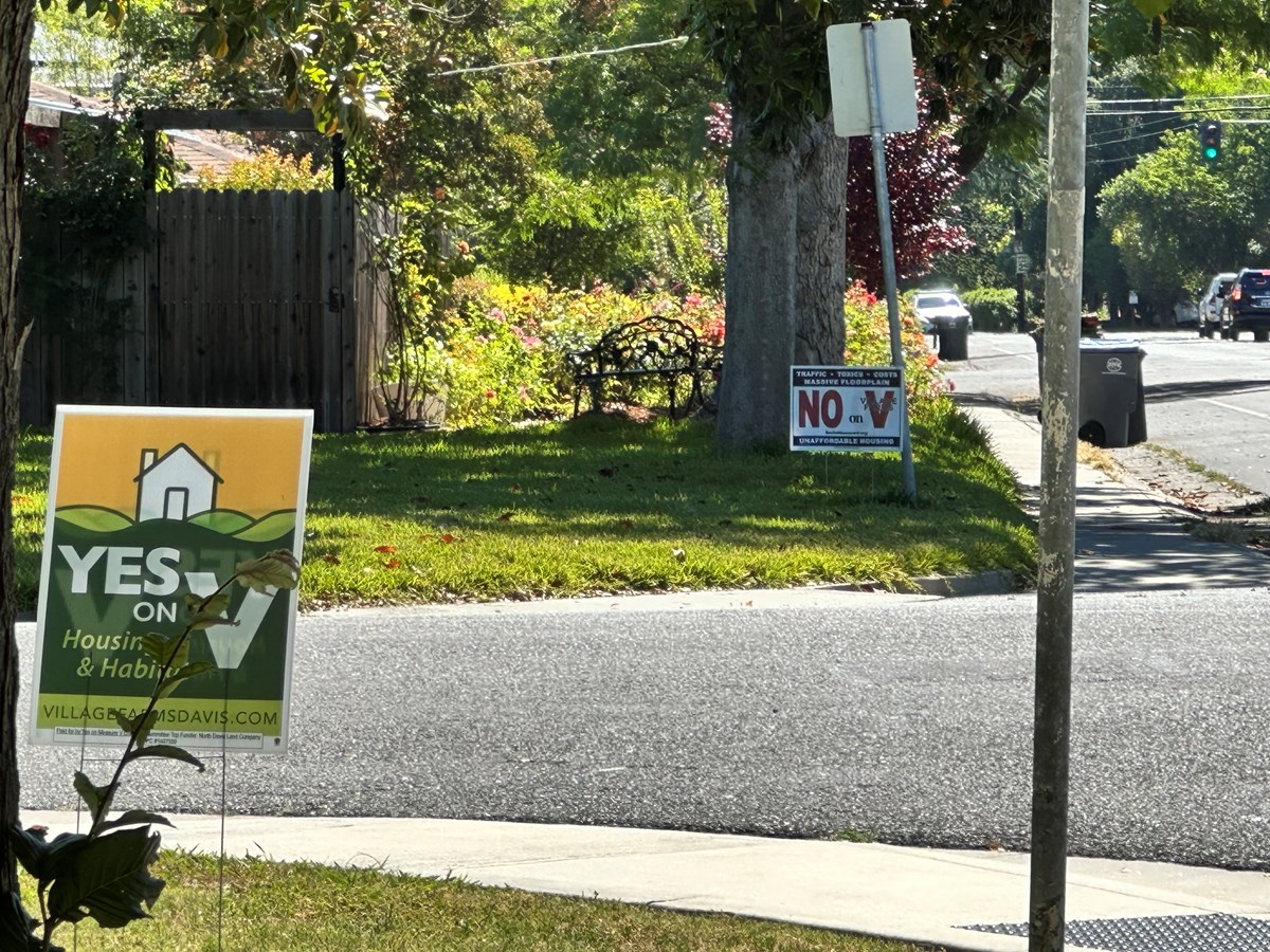 'No on V' and 'Yes on V' signs stand near each other in Davis. June 1, 2026.