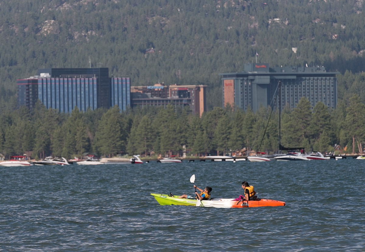 In this photo taken Tuesday, Aug. 8, 2017, Nevada casinos tower over trees along the shore of south Lake Tahoe, Calif.