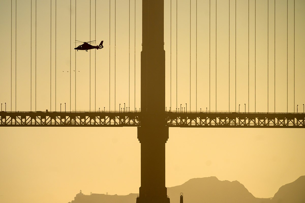 A helicopter flies past the Golden Gate Bridge while searching for missing victims after a boat accident near Alcatraz Island off San Francisco, Tuesday, July 14, 2026.