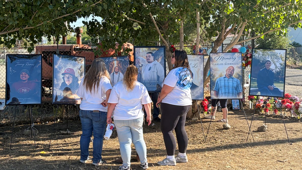Family members stand before photographs of the seven men killed in a fireworks warehouse explosion during a vigil marking one year since the blast, Wednesday, July 1, 2026, in Esparto, Calif.